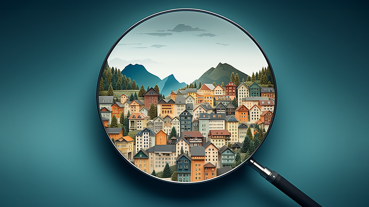 Das Bild zeigt eine Lupe, die ein Dorf betrachtet. Es zeigt, dass ein Aussenblick manchmal neue Perspektiven offenbart.